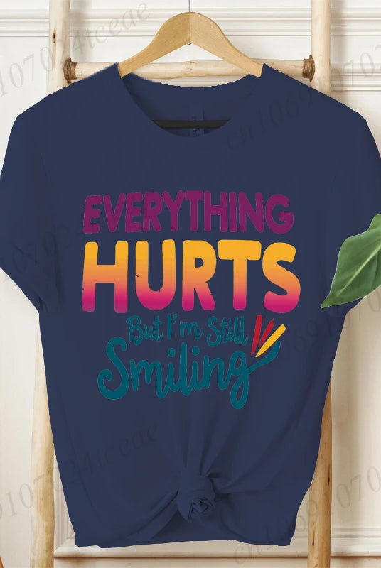 Navy blue short sleeve T-shirt with Everything Hurts But I'm Still Smiling colorful text and rainbow graphic, casual summer