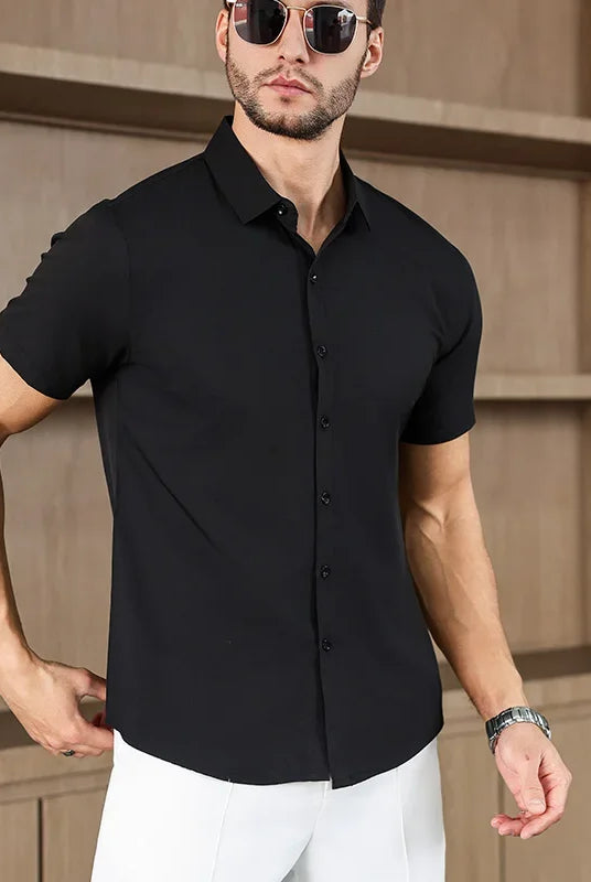 Men's black men's business casual solid color short sleeved shirt for summer fashion, no ironing, comfortable and versatile top worn by male model with sunglasses.