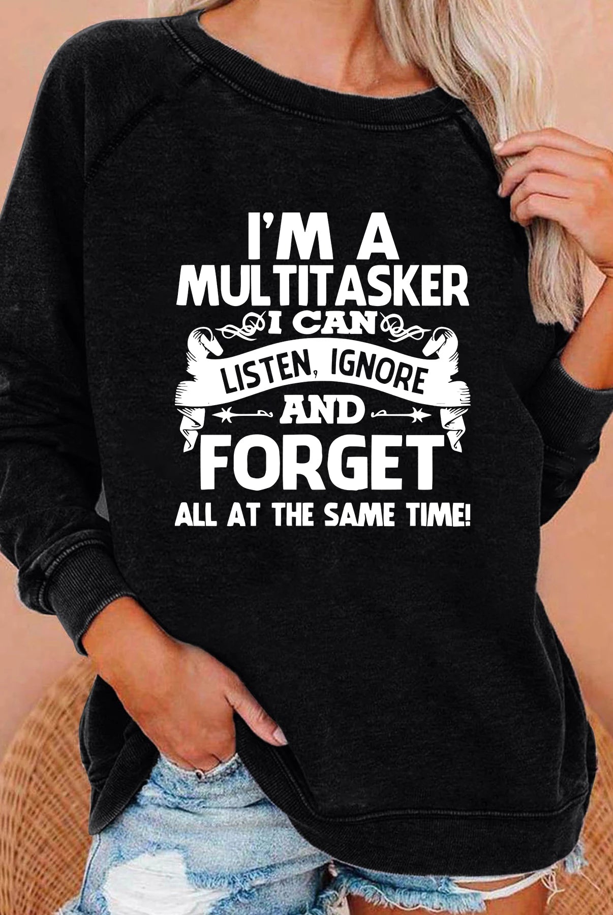 Black women's sweatshirt with white text reading I'M A MULTITASKER I CAN LISTEN, IGNORE AND FORGET for fall and winter casual wear.