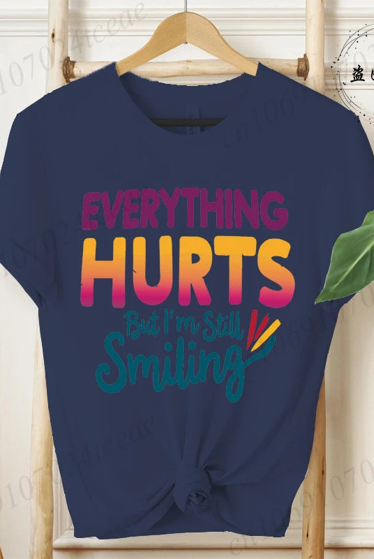 Navy blue short sleeve T-shirt with Everything Hurts But I'm Still Smiling funny sarcastic quote design, displayed on a