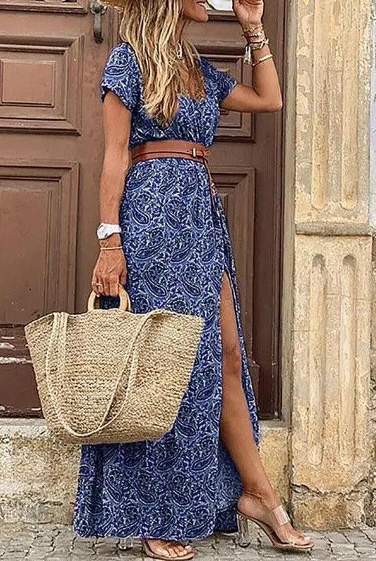 Elegant floral pleated H-shaped midi dress with V-neck, puff sleeves, waist ruching, button details, and side slit, worn by