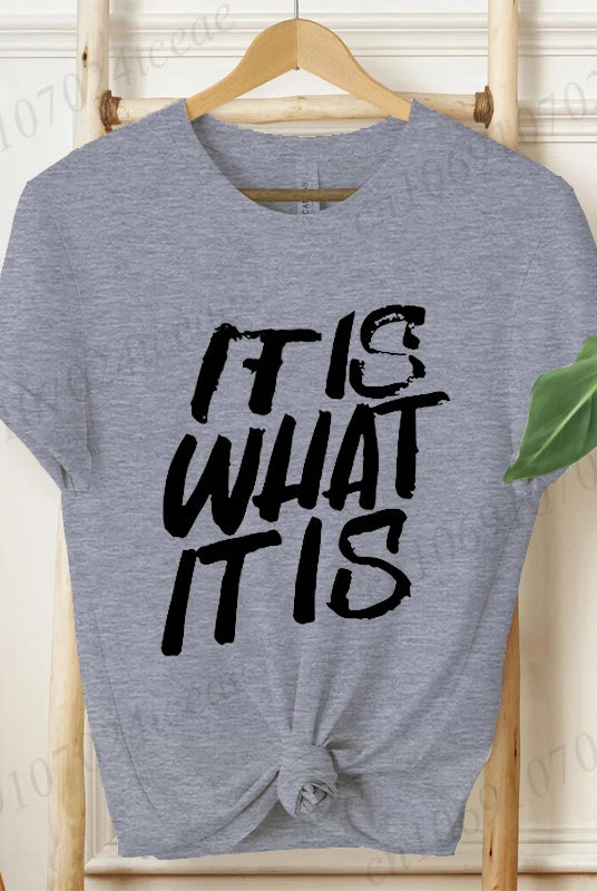 Gray women's short sleeve T-shirt with IT IS WHAT IT IS printed in bold black text, casual summer fashion tee.