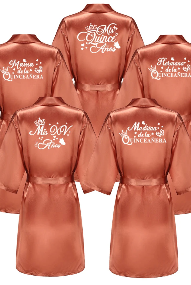 Set of six royal blue satin Quinceanera robes with personalized white print for girls' 15th birthday celebration, including titles like Mama, Hermana, and Madrina.