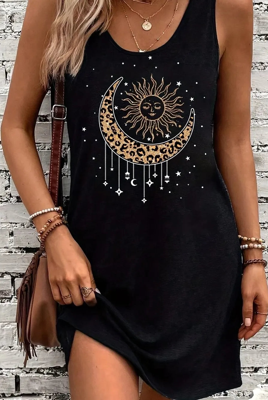 Women's summer sleeveless tank top dress with black print of a sun and moon design featuring leopard print crescent and hanging celestial symbols.