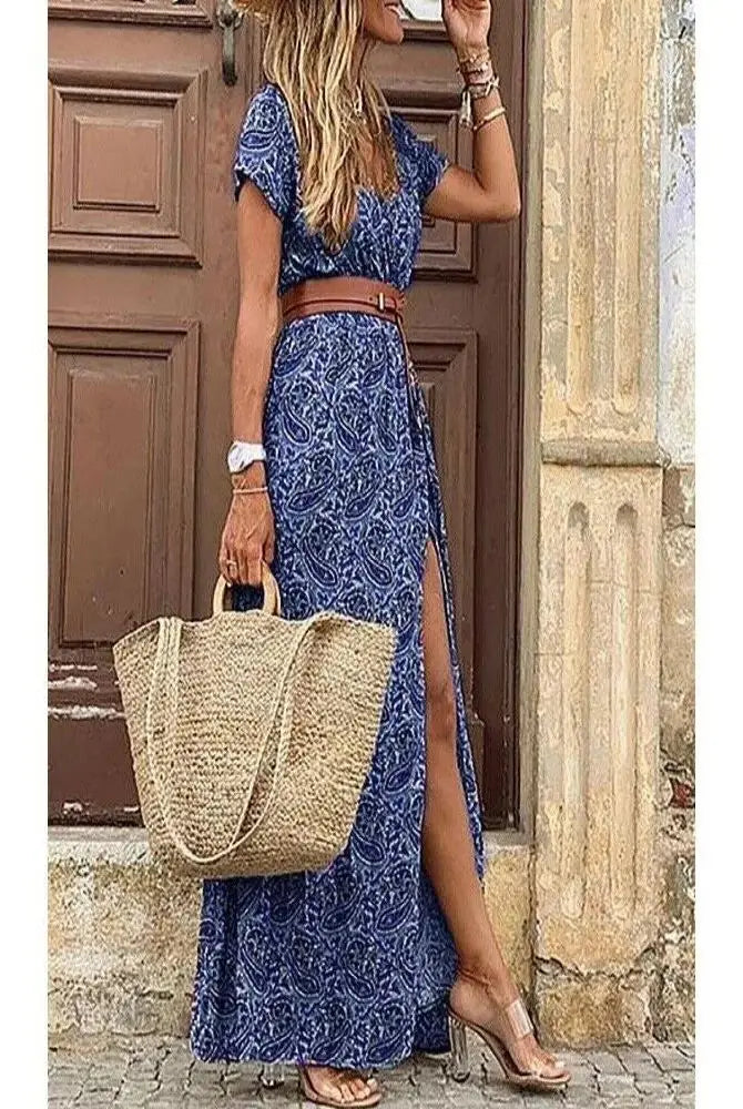 Elegant floral pleated H-shaped midi dress with V-neck, puff sleeves, ruched waist, and slit, worn by a woman with a straw