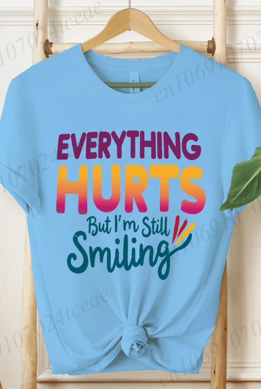 Light blue short sleeve T-shirt with Everything Hurts But I'm Still Smiling humorous quote, casual summer fashion tee shirt.