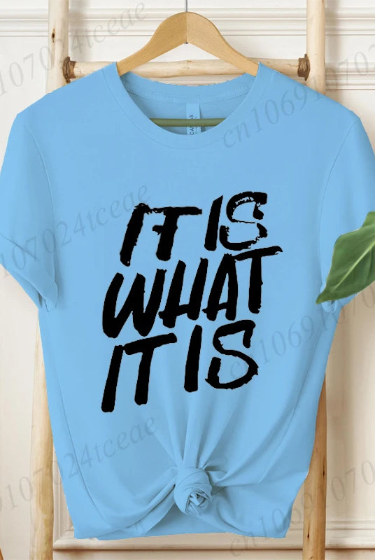 Light blue women's T-shirt with IT IS WHAT IT IS graphic text, short sleeves, tied at the waist, designed for summer fashion
