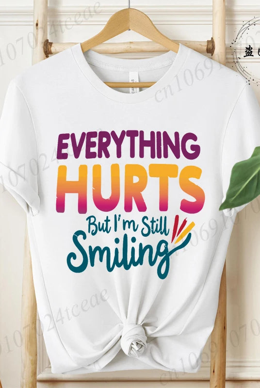 White cotton short sleeve T-shirt with Everything Hurts But I'm Still Smiling colorful graphic design, casual summer fashion