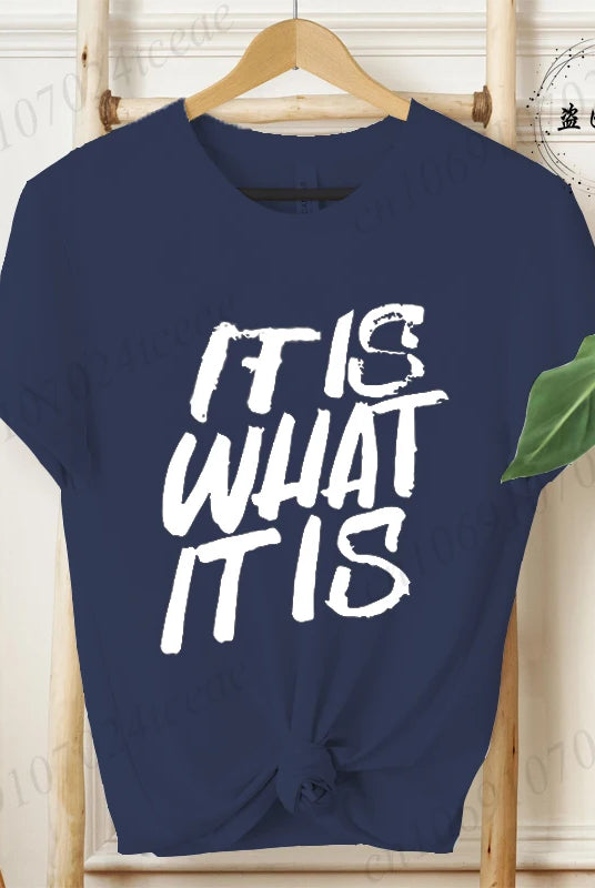 Navy blue women's IT IS WHAT IT IS design shirt with bold white text, short sleeves, casual summer fashion, knotted at the