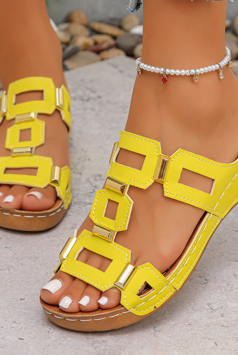 Large size Roman style women's open-toe beach sandals with yellow straps, gold accents, and a tan wedge heel, worn outdoors