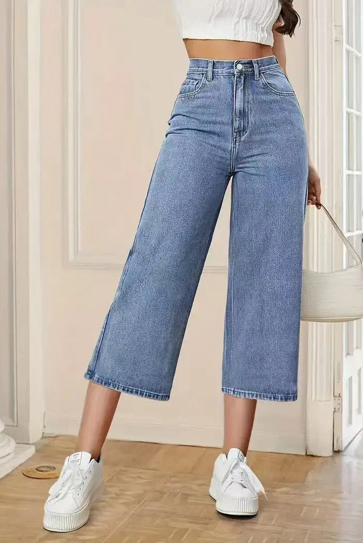 Women's High-Waisted Wide-Leg Capri Jeans in light blue denim, styled with white sneakers and a white cropped top.