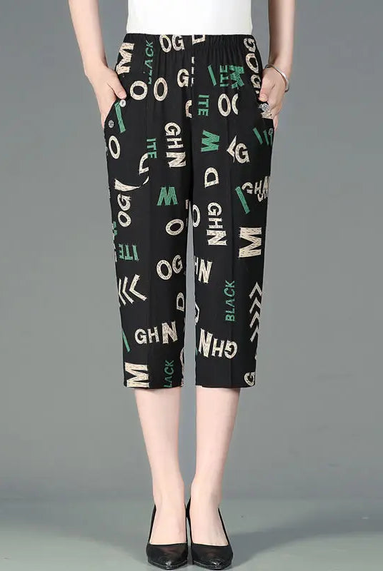 Summer new high waist Capri pants with elastic waist, casual loose straight fit, black fabric with colorful patchwork and printed letters, featuring pockets.