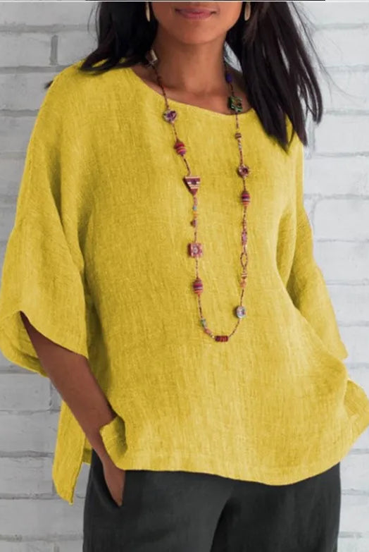 Plus size cotton blouse shirt summer O-neck three-quarter loose casual blouse top for women in yellow, worn with dark pants and colorful beaded necklace.