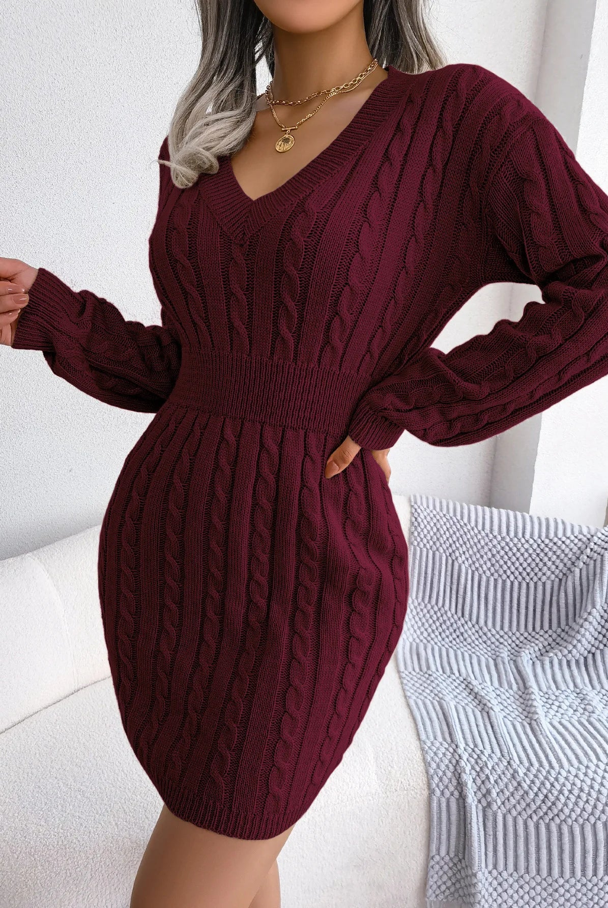 VigoCasey 2025 V Neck Khaki long sleeve knit dress with cable pattern, worn by a woman with layered gold necklaces, in a