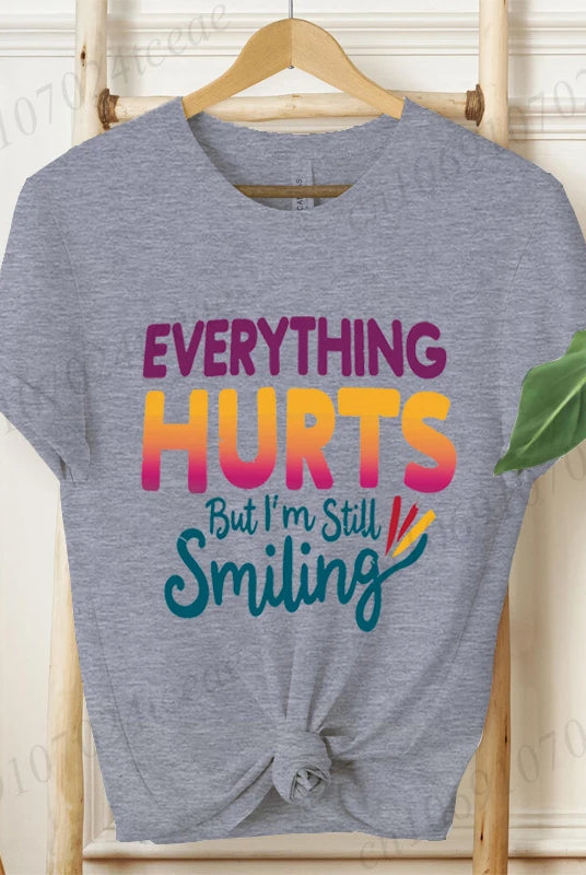 Everything Hurts But I'm Still Smiling Design shirt, short sleeve grey tee with colorful sarcastic quote for summer fashion.