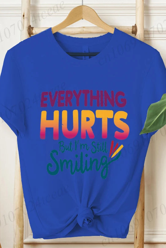 Blue short sleeve T-shirt featuring the Everything Hurts But I'm Still Smiling design, made of lightweight fabric, displayed