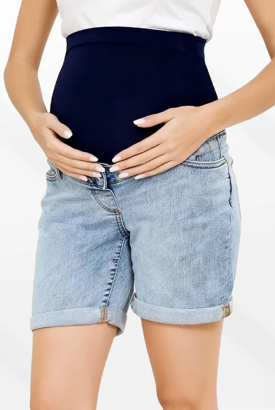 Pregnancy Capri Jeans High Waist Tummy Control Rolled Cuff Denim Shorts worn by a pregnant woman, featuring dark blue high-waist maternity jeans with rolled cuffs.