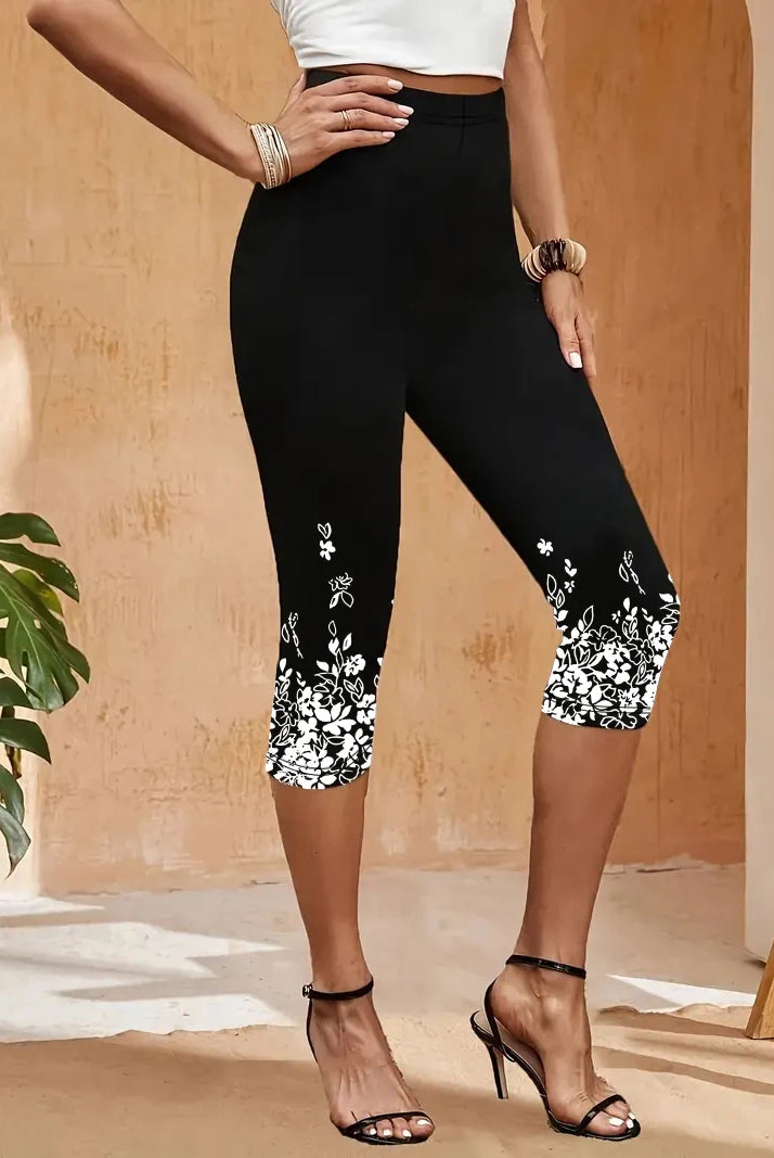 9040 Women's three-quarter leggings with white floral printed designs at the hem, black stretch fabric, styled with high