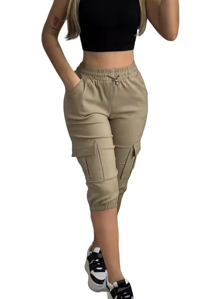 Summer Women's Slim-Fit Capri Trousers Solid Color Casual Multiple Pocket Lace-Up High Waist Tight Leggings Capri Pants in beige, paired with a black crop top and sneakers.