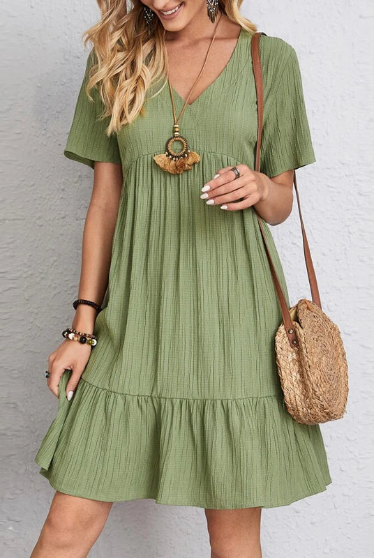 Vintage Solid Elegant Women Dress 2023 summer casual V-neck high waist A-line mini dress with short sleeves in olive green, styled with jewelry and a straw bag.