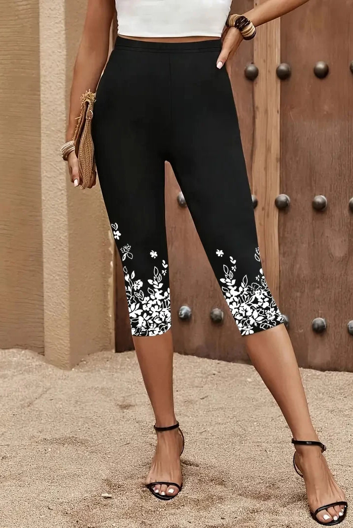 9040 Women's Three-Quarter Leggings with printed white floral designs on black fabric, high waist, suitable for casual wear.