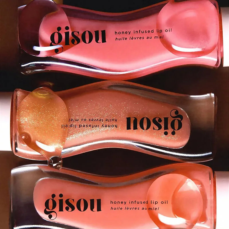 Gisou Moisturizing Watermelon Lip Balm Lip Oil Gloss in pink and peach tones with honey-infused formula, curved packaging