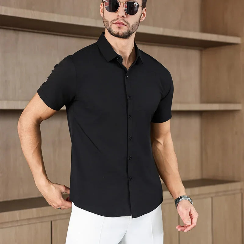Men's black men's business casual solid color short sleeved shirt for summer fashion, no ironing, comfortable and versatile top worn by male model with sunglasses.