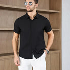 Men's business casual short-sleeved solid color shirt for summer, no iron, lightweight, versatile, worn by male model with white pants.