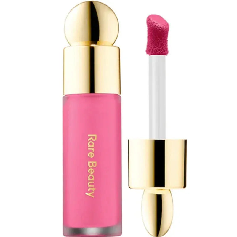 Rare Beauty Soft Pinch Liquid Blush in pink with a gold cap and applicator wand for smooth, long-lasting, and plump makeup application.