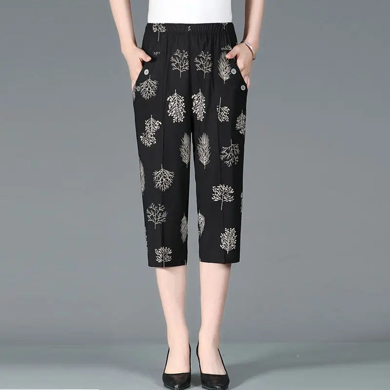 Summer new high waist Capri pants with elastic waistband, casual loose fit, black fabric with white patchwork tree prints and pockets.