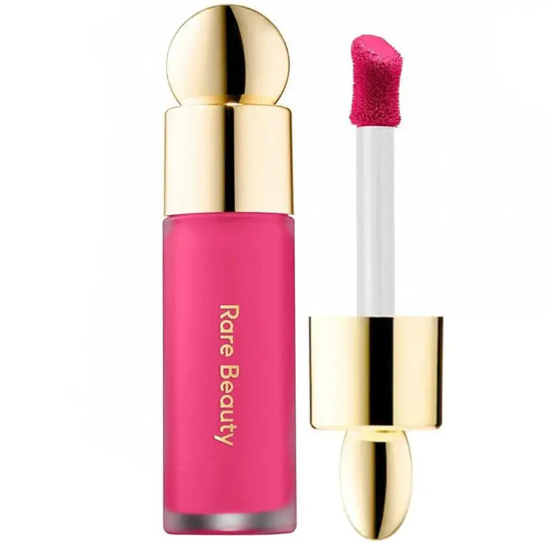 Rare Beauty Soft Pinch Liquid Blush in vibrant pink with gold cap and applicator wand, designed for smooth, long-lasting, plump makeup application.