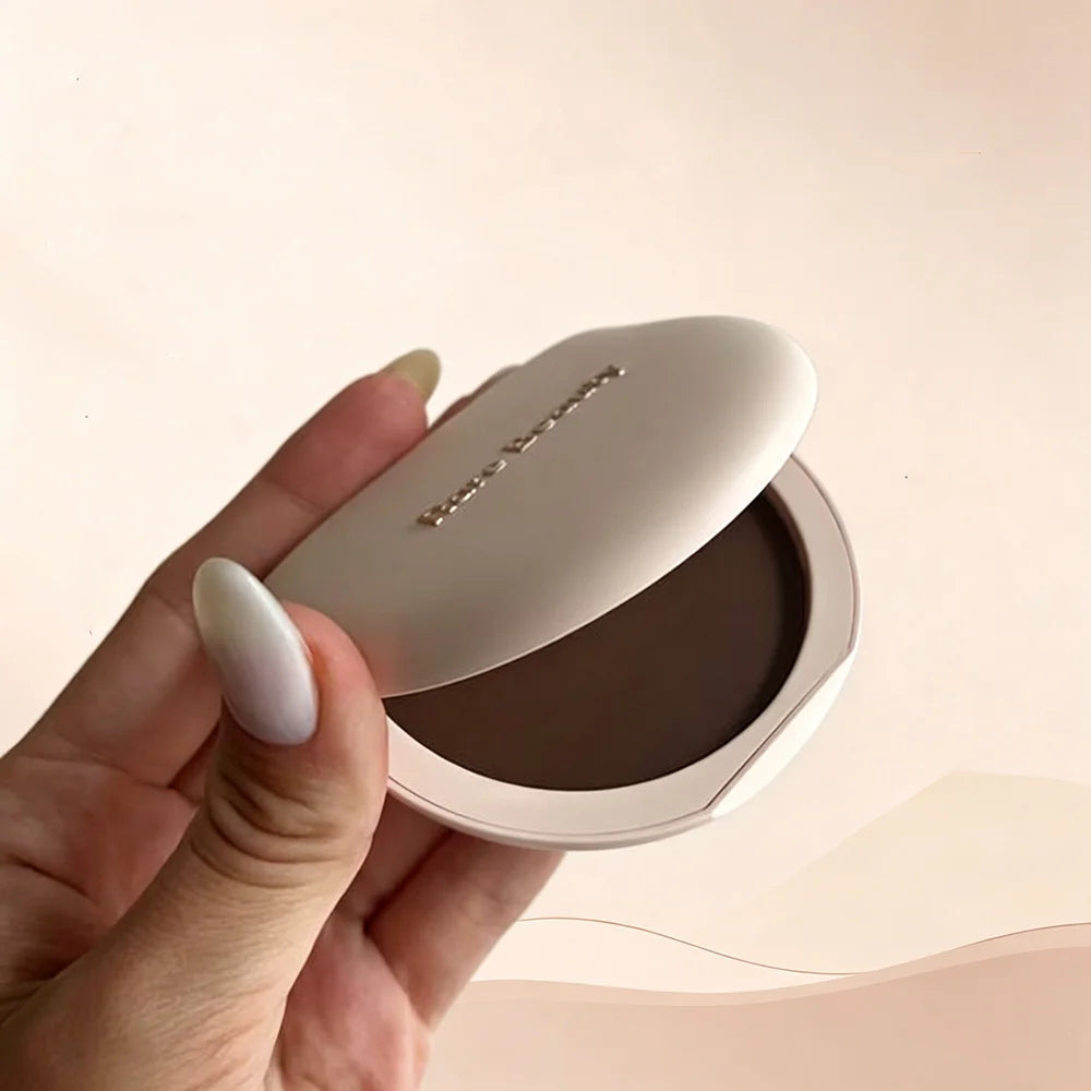Rare Beauty Stay Genuine Shaded Compact Setting Powder in a beige case with a smooth, rounded lid, designed for oil control