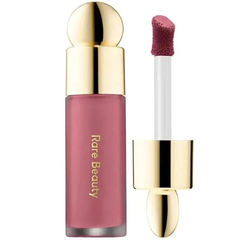 Rare Beauty Soft Pinch Liquid Blush in pink with a gold cap and applicator wand for smooth, long-lasting, and plump makeup application.