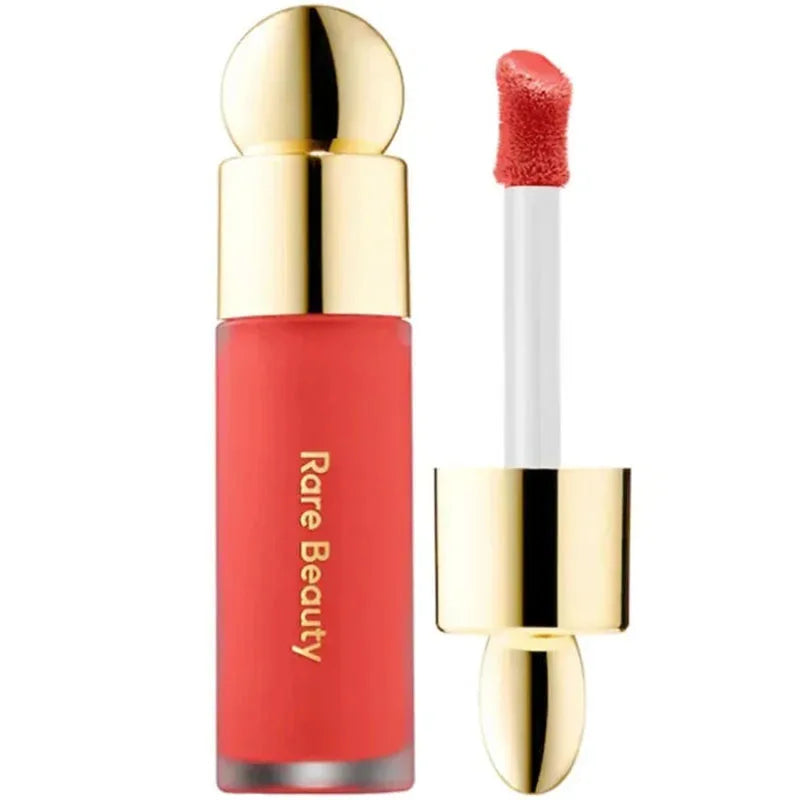 Rare Beauty Soft Pinch Liquid Blush in coral shade with gold cap and applicator wand for smooth, long-lasting, plump makeup.