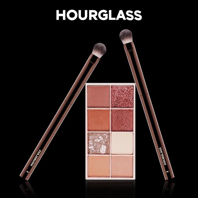 Hourglass Makeup Brushes Powder Foundation Concealer Blusher Bronzer Eye Shadow Eyebrow Eyeliner Sculpting Brush set with brown handles and soft bristles, alongside a neutral-toned eyeshadow palette.