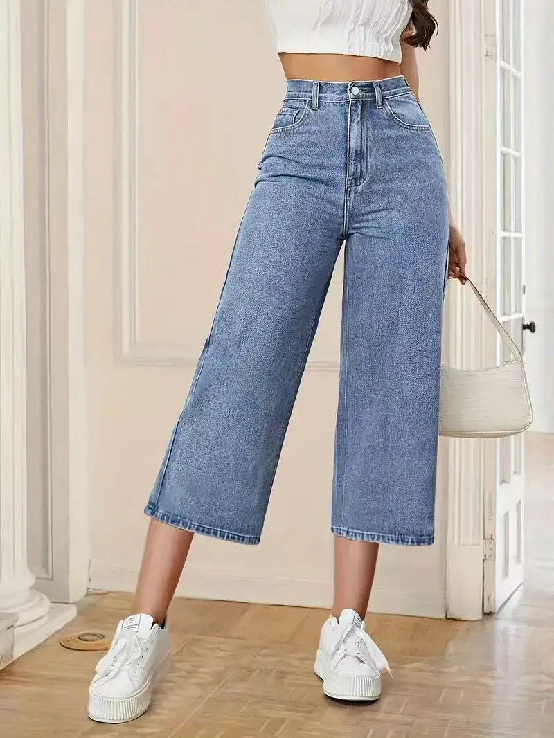 Women's High-Waisted Wide-Leg Capri Jeans in light blue denim, styled with white sneakers and a white cropped top.