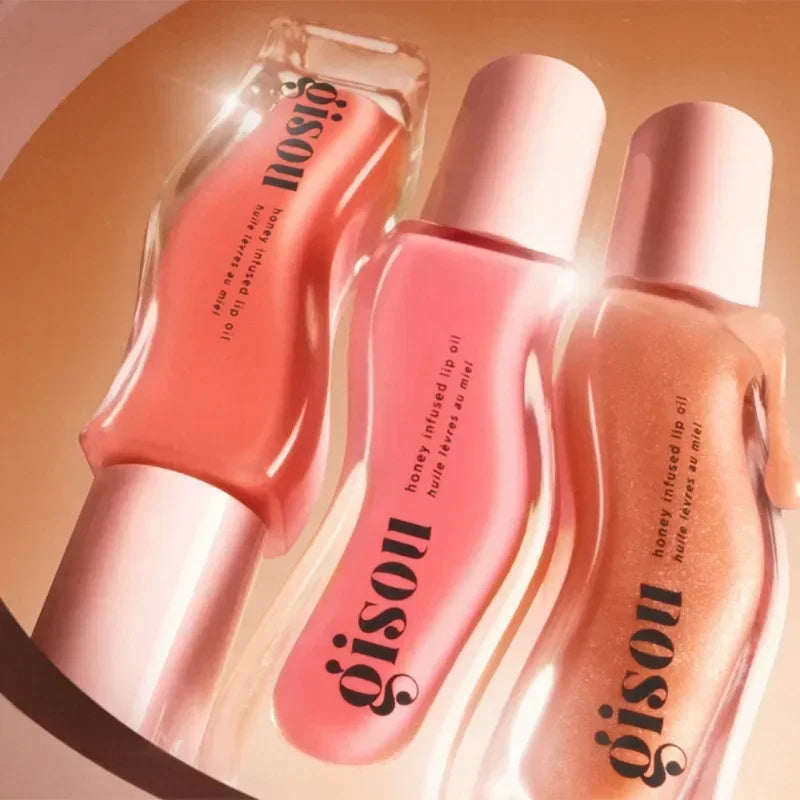Gisou Moisturizing Watermelon Lip Balm Lip Oil Gloss Care Of The Lips bottles in pink, peach, and beige tones with white