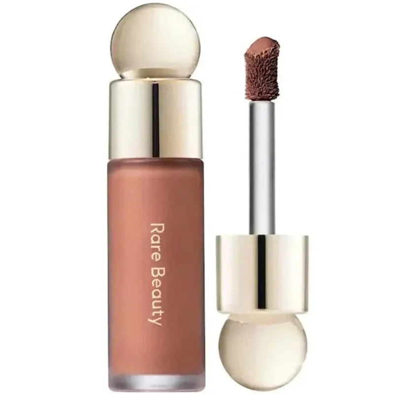 Rare Beauty Soft Pinch Liquid Blush in nude shade with a doe-foot applicator and gold accents, designed for a silky, long-lasting, plump finish.