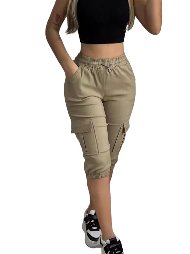 Summer Women's Slim-Fit Capri Trousers Solid Color Casual Multiple Pocket Lace-Up High Waist Tight Leggings Capri Pants in beige, paired with a black crop top and sneakers.