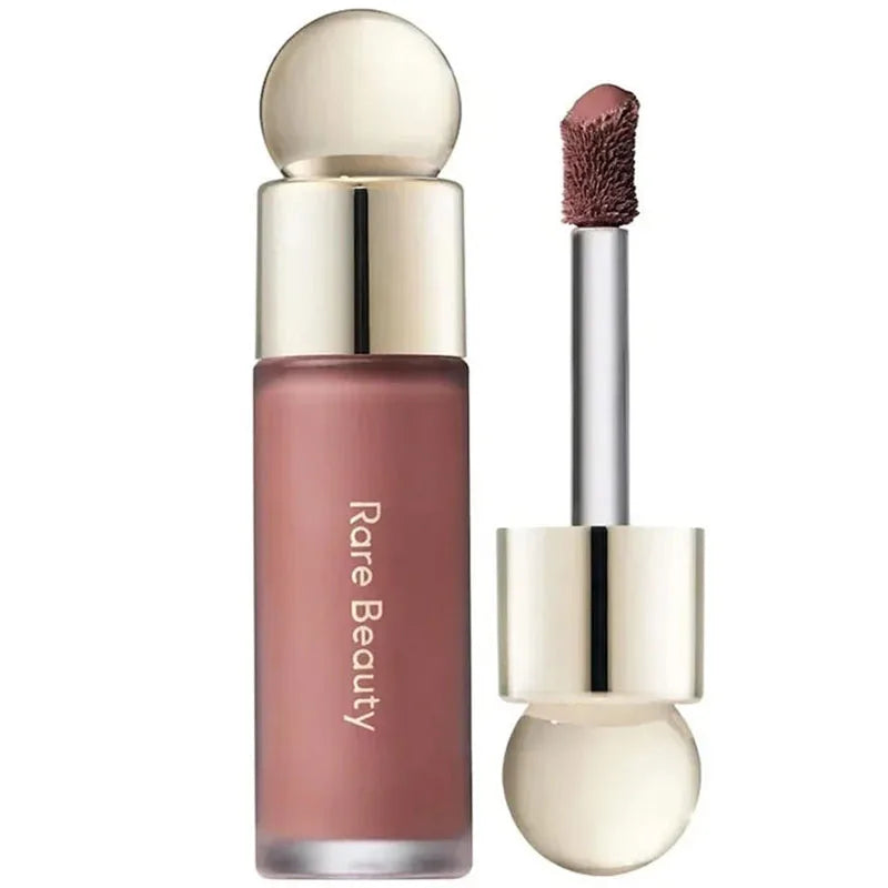 Rare Beauty Soft Pinch Liquid Blush in mauve with a gold cap and applicator wand for a smooth, long-lasting, plump makeup look.